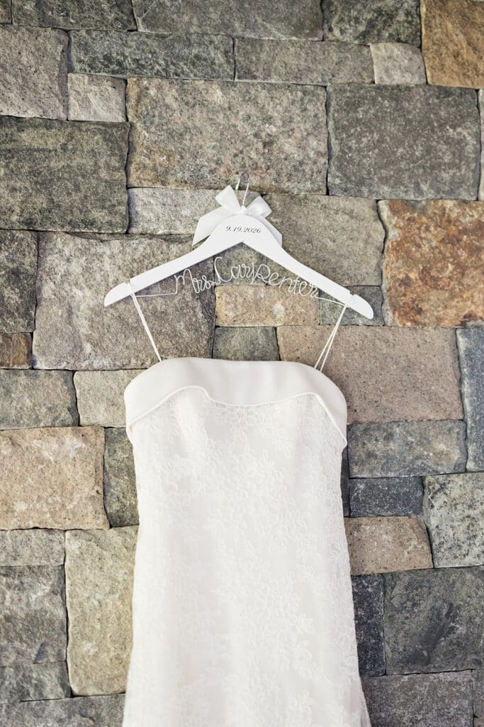 A wedding dress hanging on a hanger that says "Mrs. Carpenter"