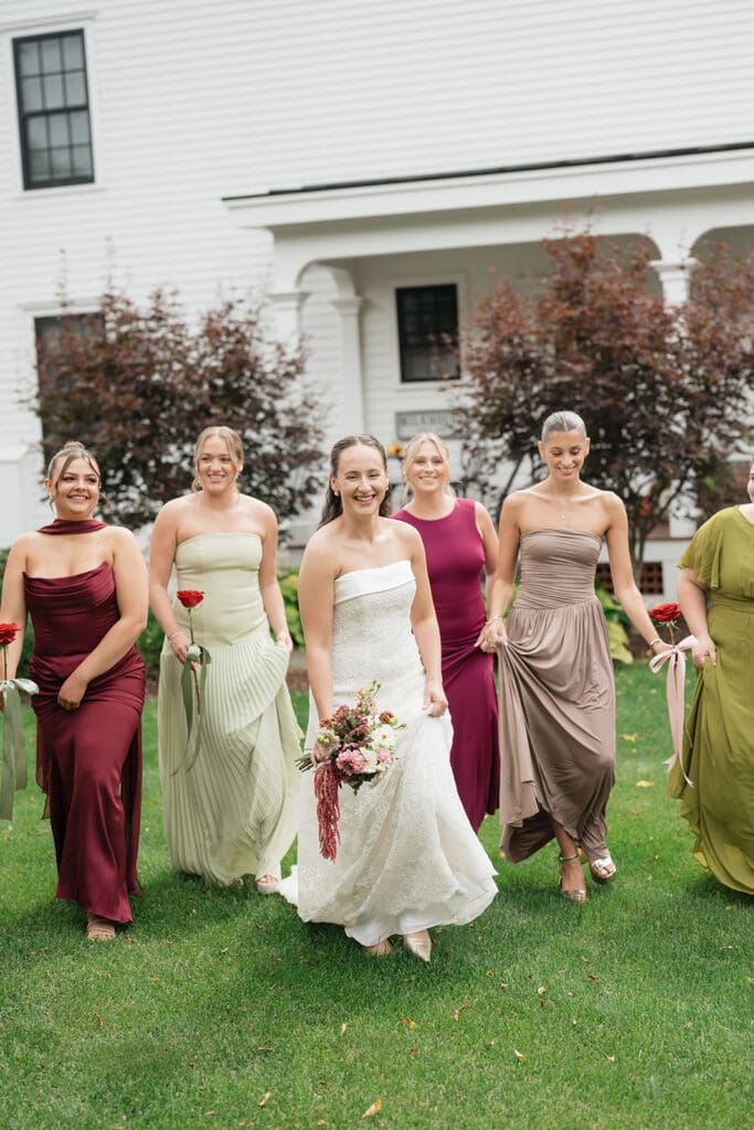 Bridesmaids walk with the bride outside of the Barnstead Inn on her wedding day. 