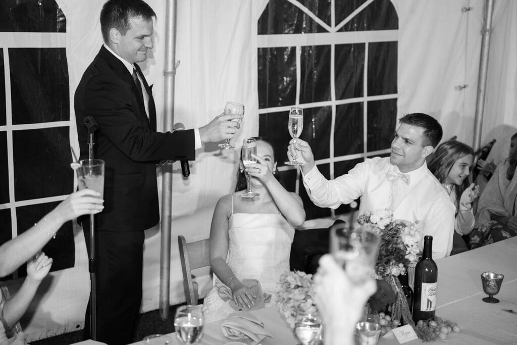 The bride and groom cheering champagne glasses with the best man. 