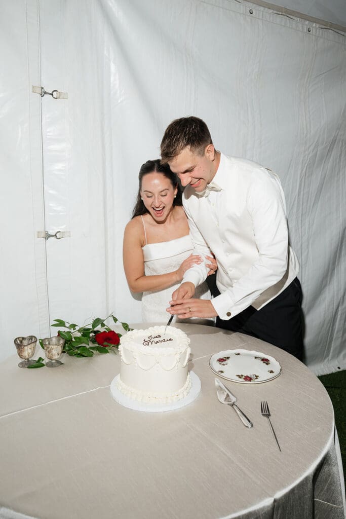 The bride and groom do their cake cutting together at their Barnstead Inn Wedding. 